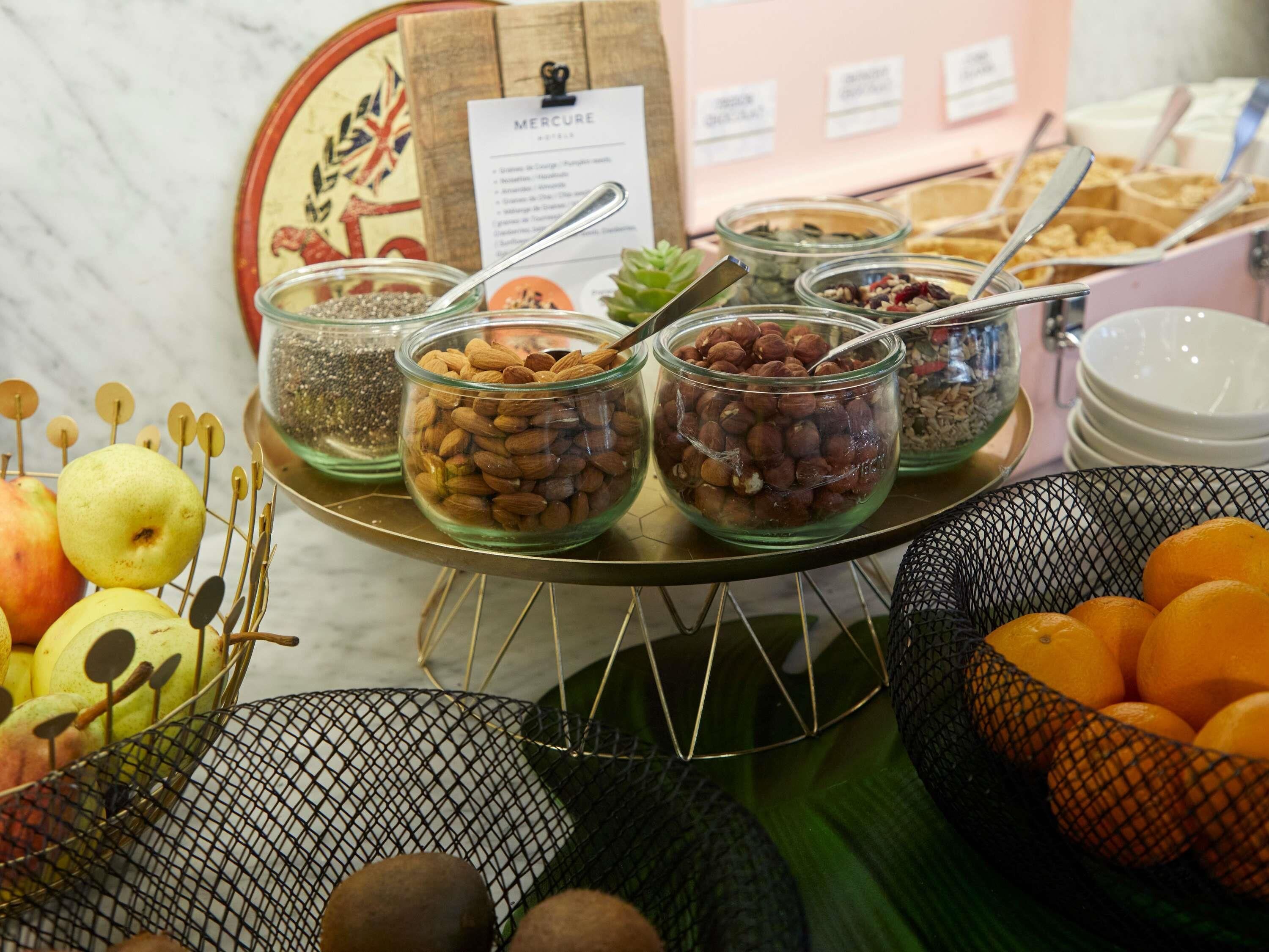 A buffet with various food items including nuts, fruits, and cereals.