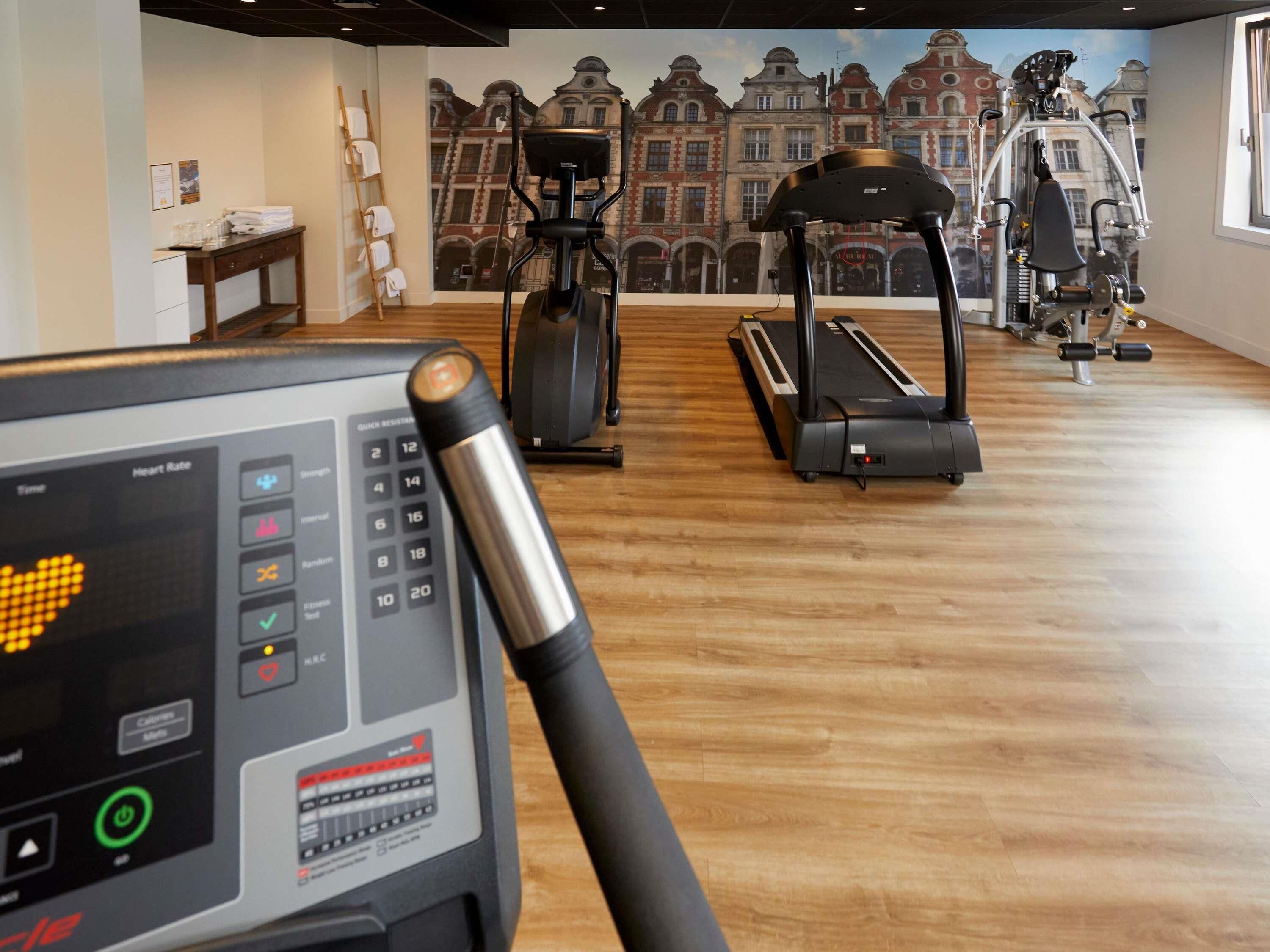 A gym with treadmills, a stationary bike, and a rowing machine.