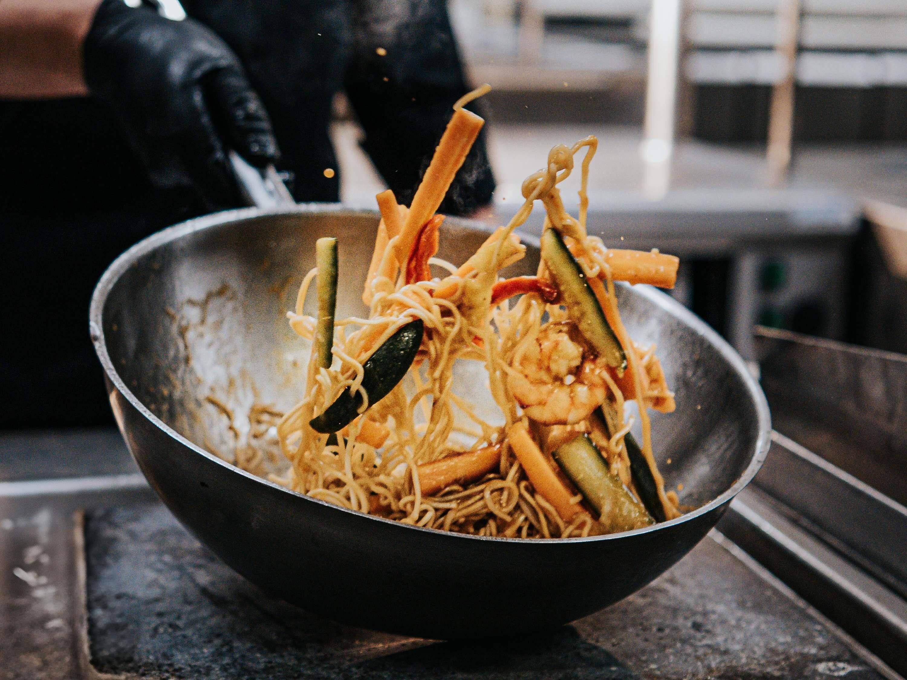 A bowl of stir-fried noodles with vegetables and shrimp.