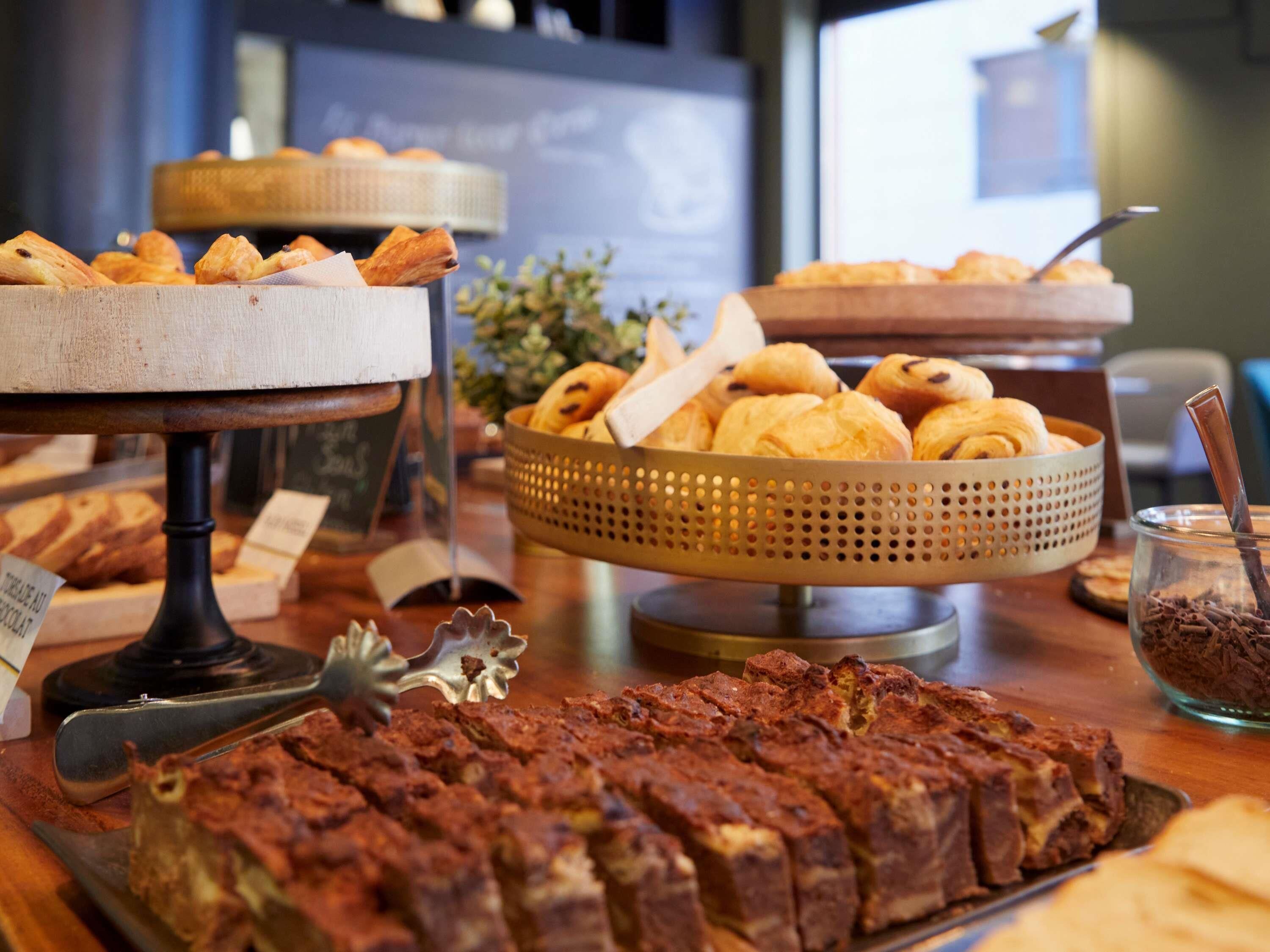 Un buffet proposant une variété de produits de boulangerie, notamment des pâtisseries et du pain.