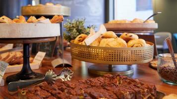 Un buffet proposant une variété de produits de boulangerie, notamment des pâtisseries et du pain.