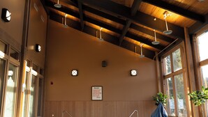 Una piscina interior con vigas de madera y grandes ventanales.