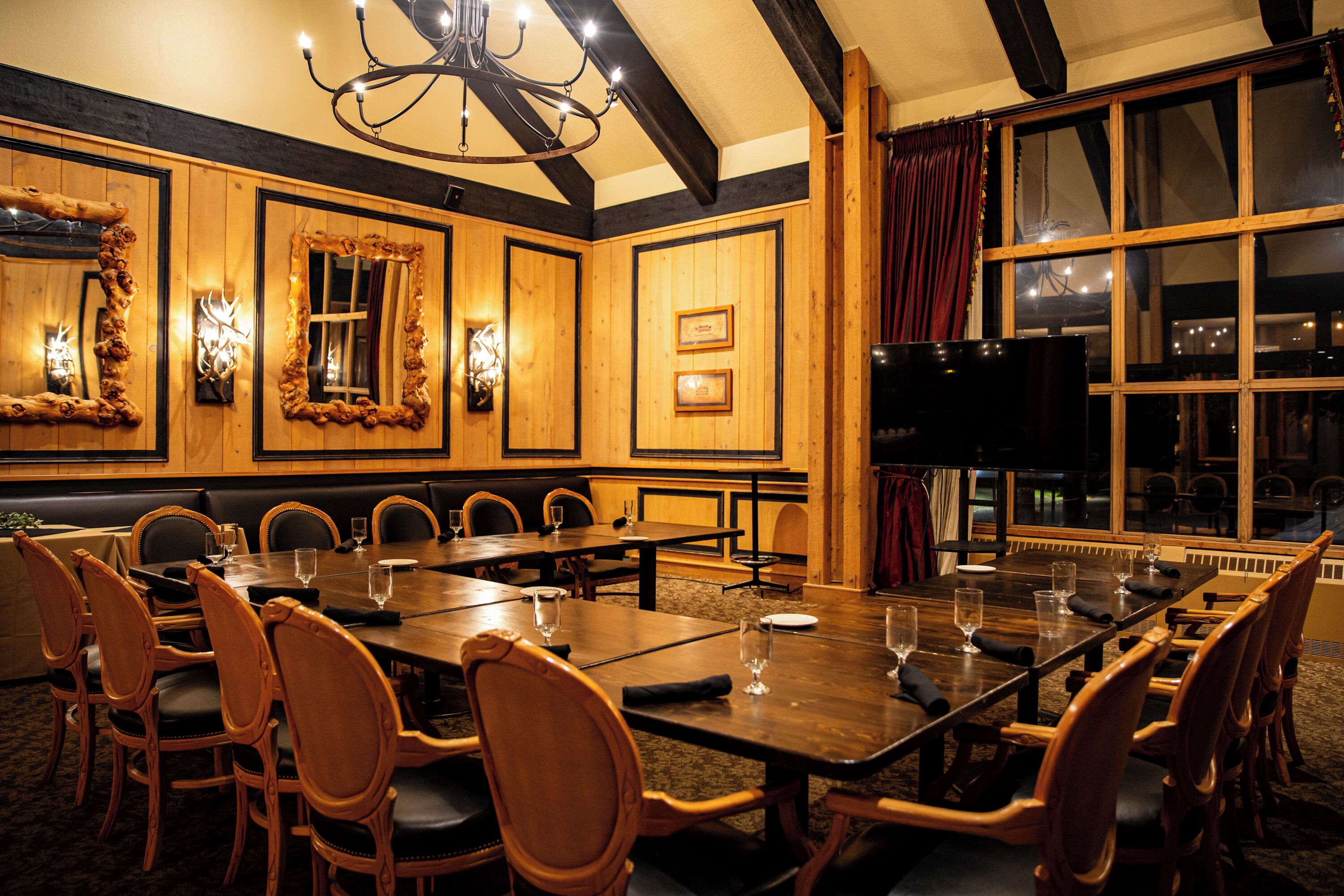 A conference room with a long table, multiple chairs, and framed mirrors on the walls.
