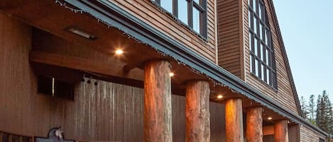 A large building with a wooden facade, large windows, and a covered entrance area with columns.