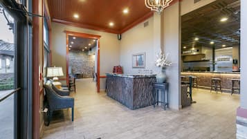 A lobby with a reception desk, seating area, and a bar.
