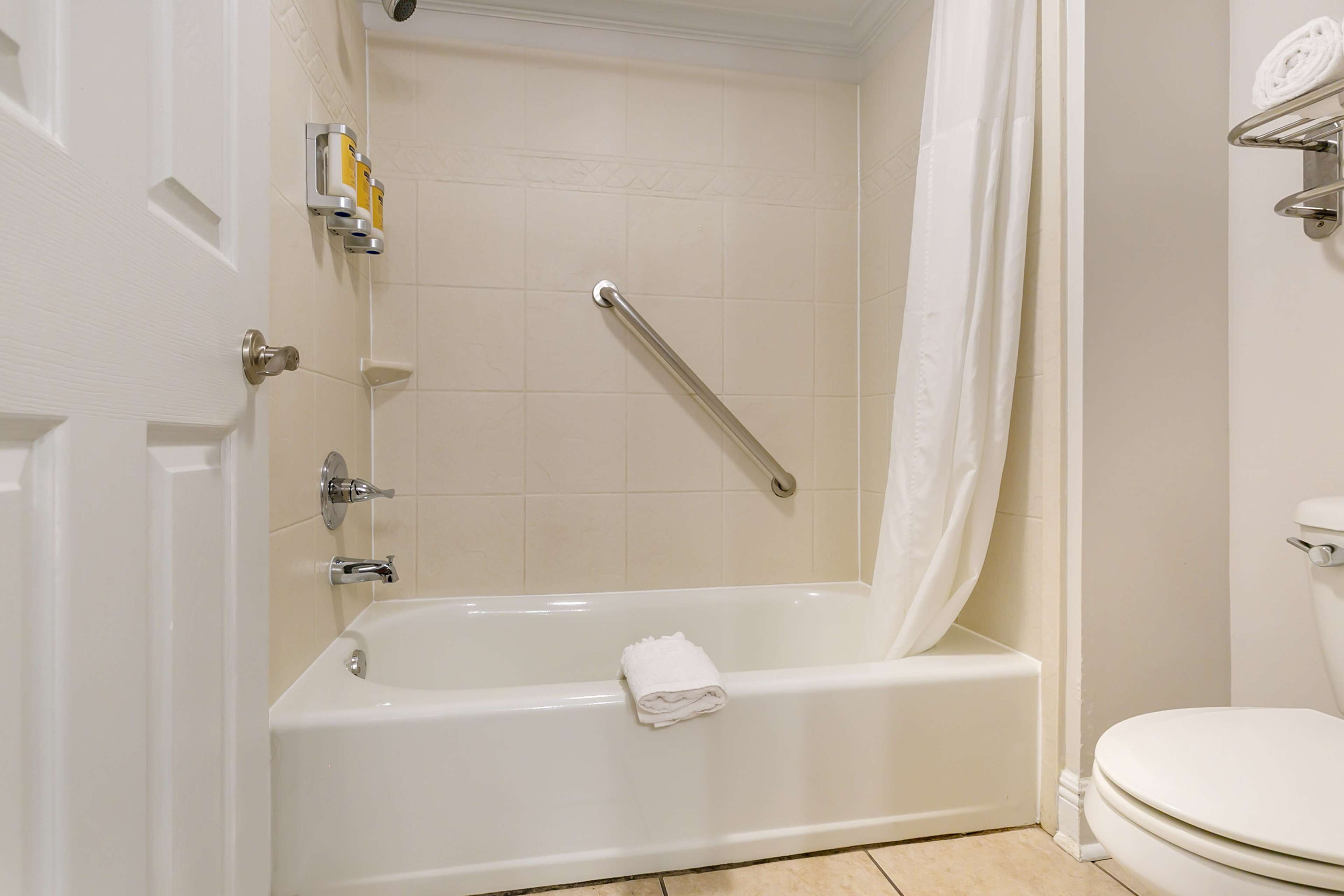 A bathroom with a bathtub, toilet, and a shower area.