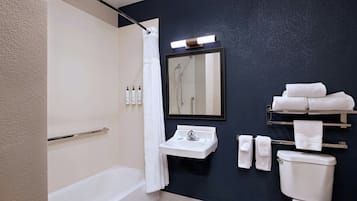 Ein modernes Badezimmer mit Badewanne, Waschbecken, Toilette und Spiegel.