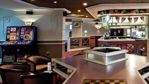 Un vestíbulo con zona de bar, mesa de billar y jukebox.