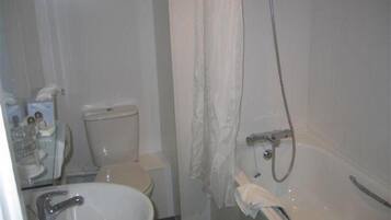 A small bathroom with a toilet, sink, and shower.