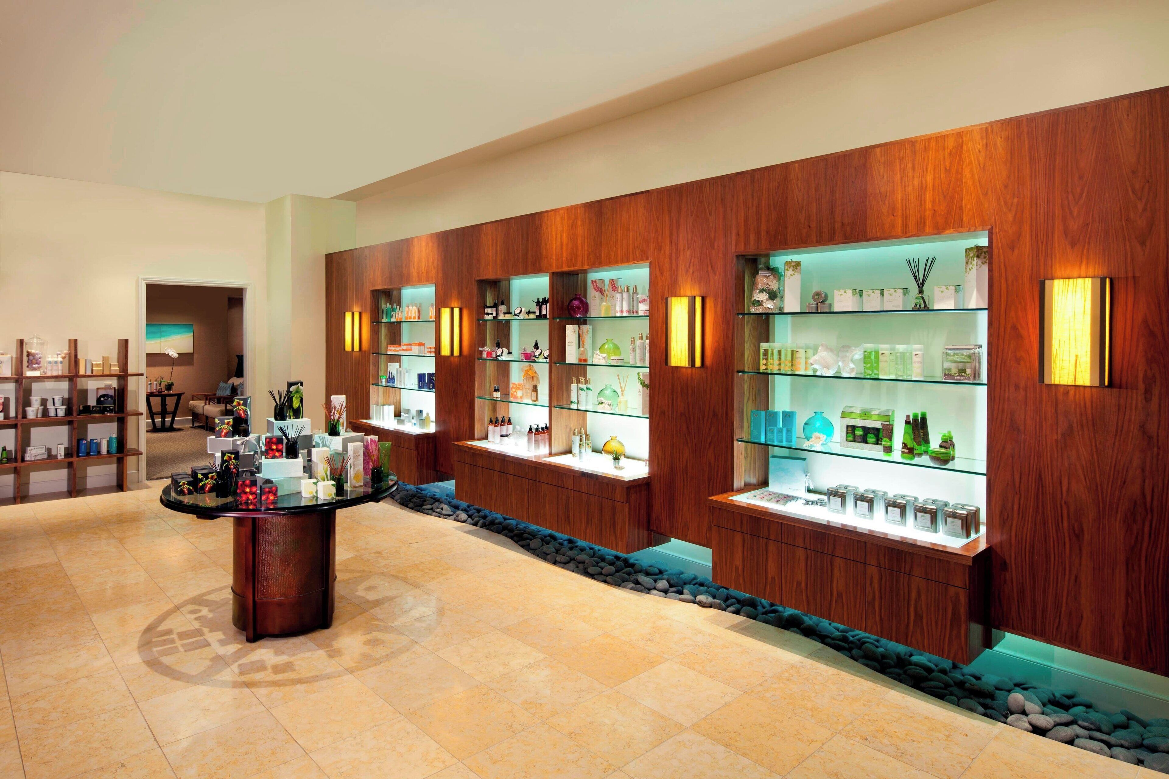 A hotel lobby with wooden paneling, a reception desk, and glass display cases with various items.
