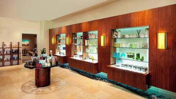 A hotel lobby with wooden paneling, a reception desk, and glass display cases with various items.