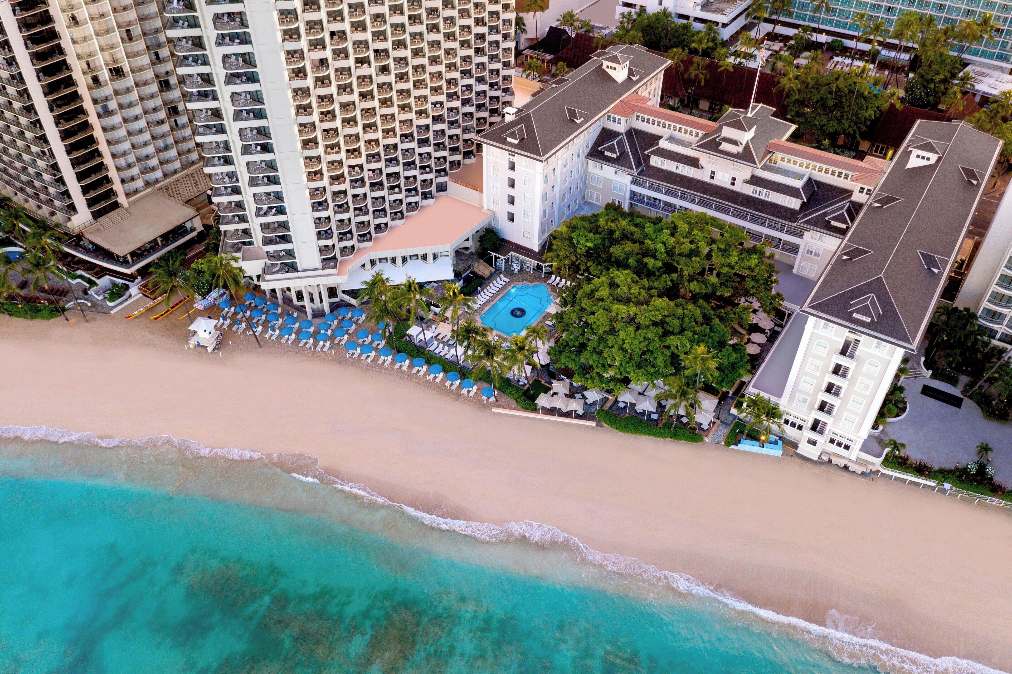 Um hotel moderno com vários sacadões, piscina e localização à beira-mar.