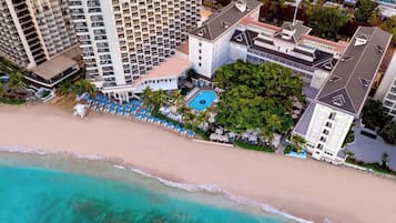 Um hotel moderno com vários sacadões, piscina e localização à beira-mar.