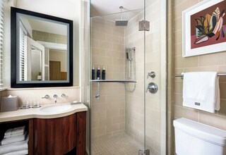 A bathroom with a sink, mirror, shower, and toilet.