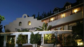 The Normandie Hotel with a modern design, featuring a prominent entrance and outdoor seating area. - The Normandie Hotel (Port of Spain)