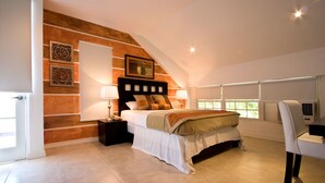 A bedroom with a bed, nightstands, a chair, and a window. - The Normandie Hotel (Port of Spain)