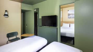 Ett hotellrum med två sängar, en TV, ett skrivbord och en stol.
