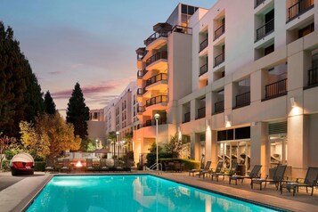 Una piscina al aire libre, sombrillas, tumbonas