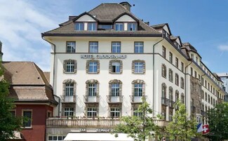 Hotelli nimeltä ”Hotel Glockenhof” edustaa klassista eurooppalaista arkkitehtuurityyliä, ja siinä on useita ikkunoita ja parvekkeita.
