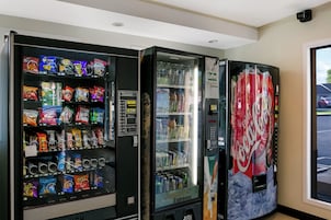 Una máquina expendedora con aperitivos y una máquina de Coca-Cola.