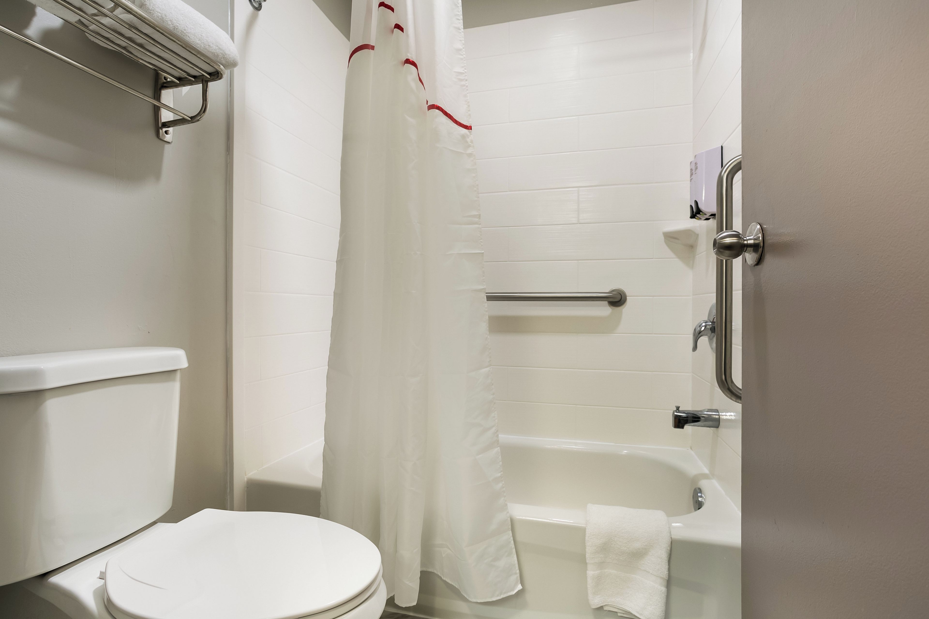 Een badkamer met toilet, bad en douchegordijn.