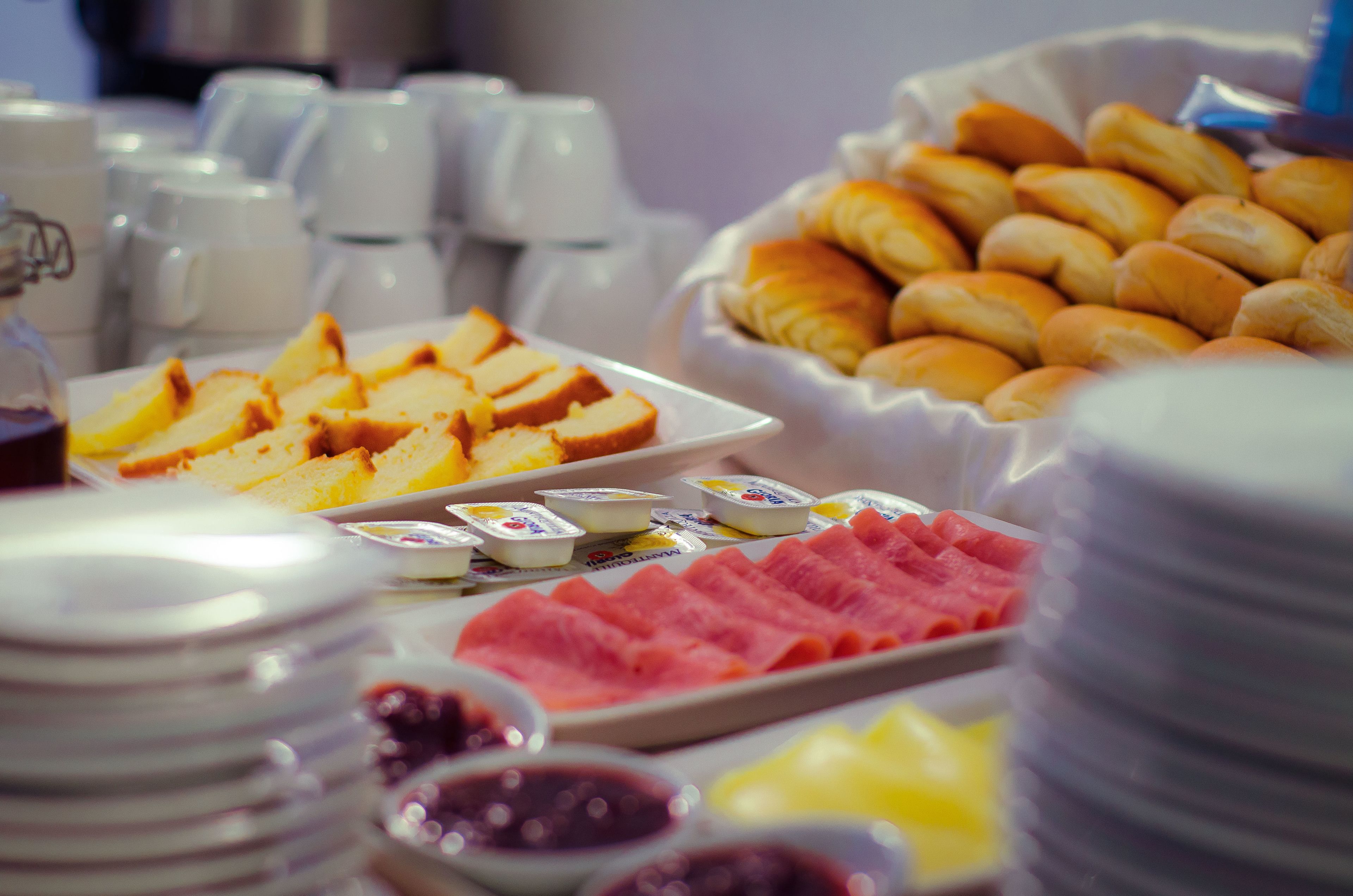 Un buffet proposant une variété de plats, notamment du pain, des pâtisseries et de la viande.