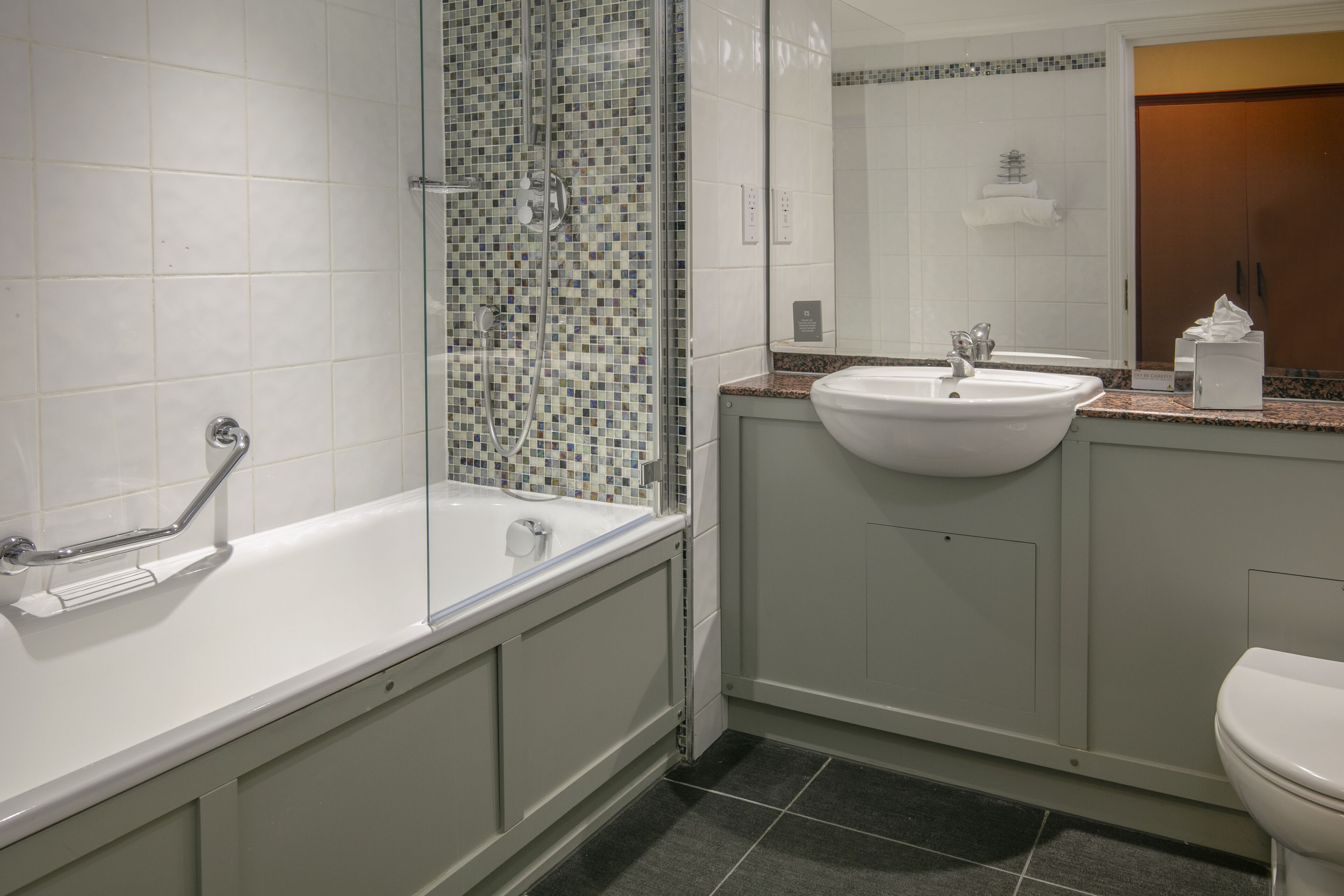 Un baño con bañera, lavamanos e inodoro.