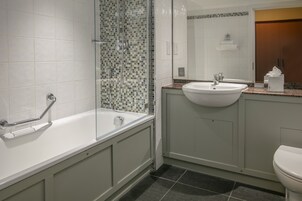Un baño con bañera, lavamanos e inodoro.