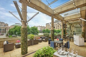An outdoor seating area with tables, chairs, and potted plants. - Sheraton Grand Hotel & Spa, Edinburgh (Edinburgh)