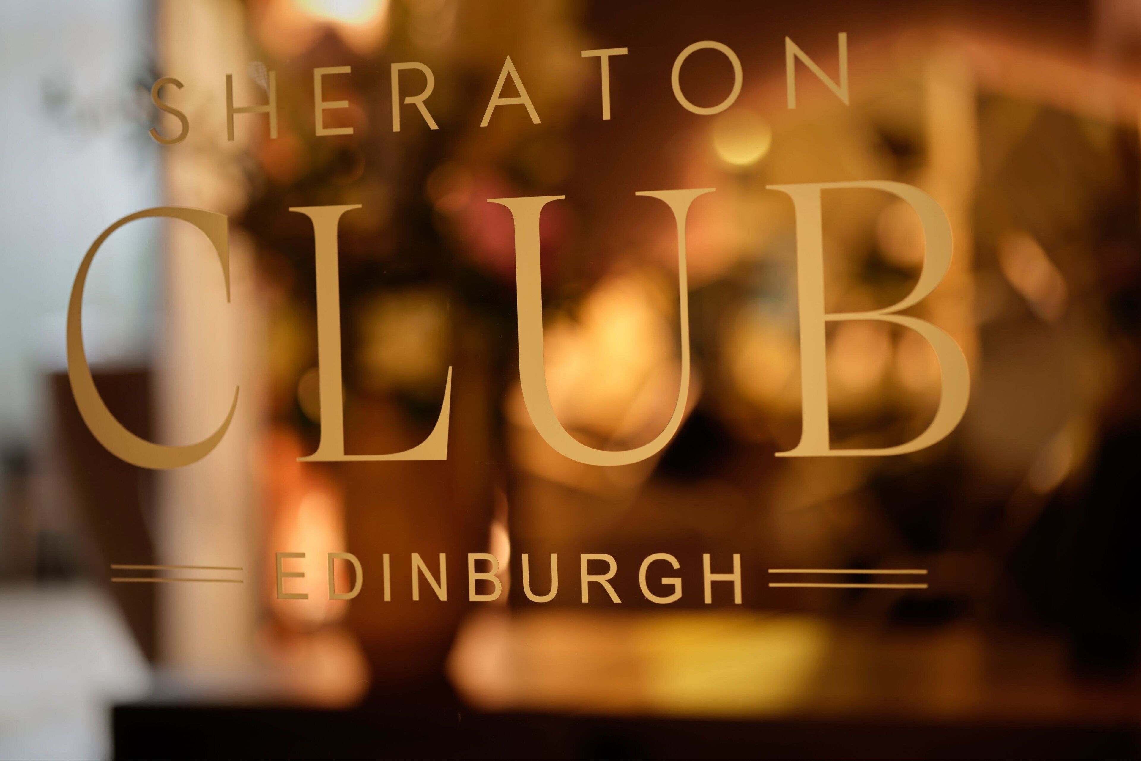 Ein unscharfer Innenbereich eines Sheraton Clubs in Edinburgh mit sichtbarem Text.