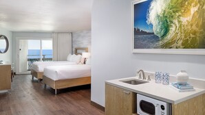 A hotel room with a bed, a desk, a small kitchenette, and a view of the ocean. - The Wayfarer San Diego (San Diego)