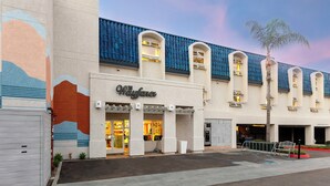 A hotel with a modern facade, large windows, and a palm tree in the foreground. - The Wayfarer San Diego (San Diego)
