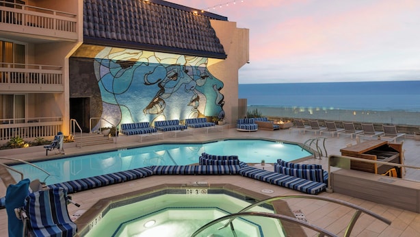 A pool area with lounge chairs and a hot tub, overlooking the ocean. - The Wayfarer San Diego (San Diego)