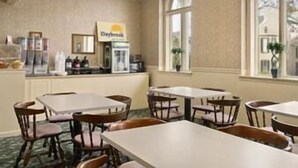 A hotel room with a dining area, a coffee machine, and a window with a view. - Days Inn by Wyndham Waynesboro (Waynesboro)