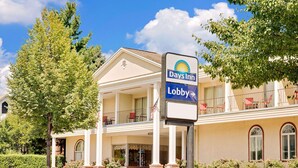 A Days Inn lobby with a white facade, multiple windows, and a balcony with red chairs. - Days Inn by Wyndham Waynesboro (Waynesboro)