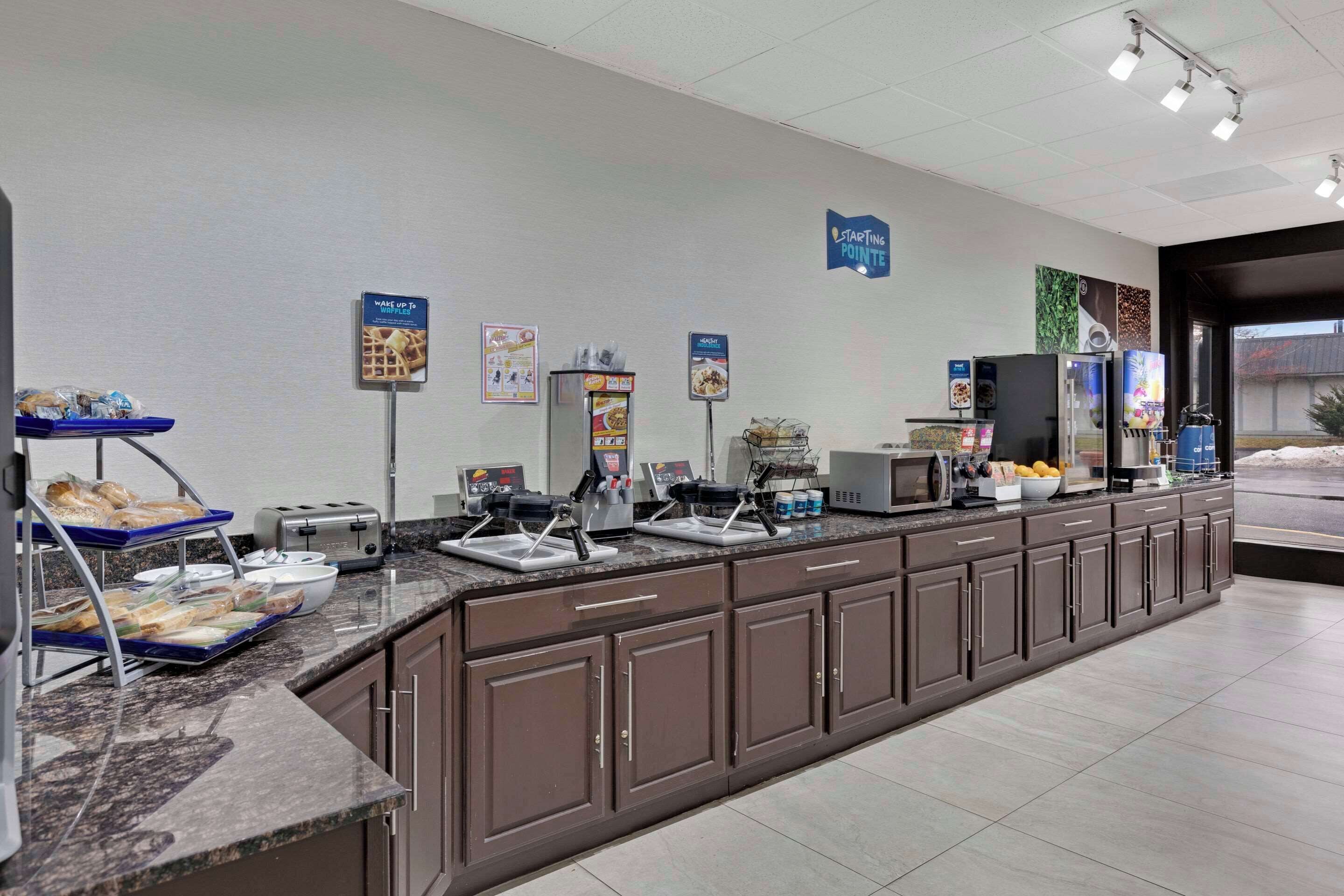 A breakfast bar with a variety of food items and a coffee machine.