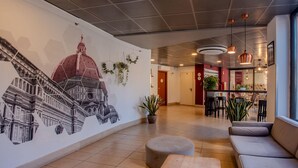 A lobby with a mural, seating area, and a bar.