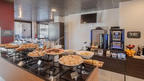 A buffet area with various food items, a coffee machine, and a sign indicating a healthy and bio section.