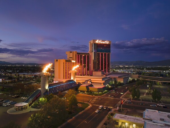 A large hotel with a prominent 'Atlantis' sign, a parking area, and a view of the surrounding cityscape.