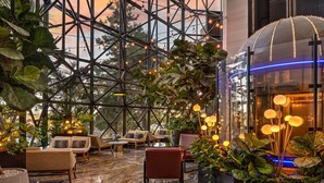 A spacious lobby with a high ceiling, modern seating, and a large glass enclosure with ambient lighting. - Atlantis Casino Resort Spa (Reno)