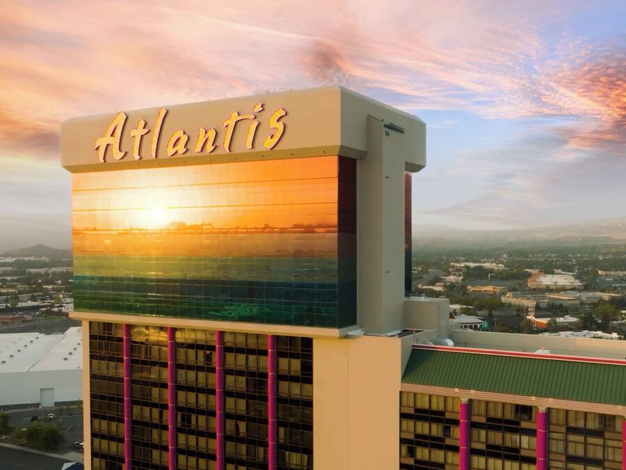 Hotel 'Atlantis', con un grande cartello, una moderna facciata in vetro e vista sulla città circostante.