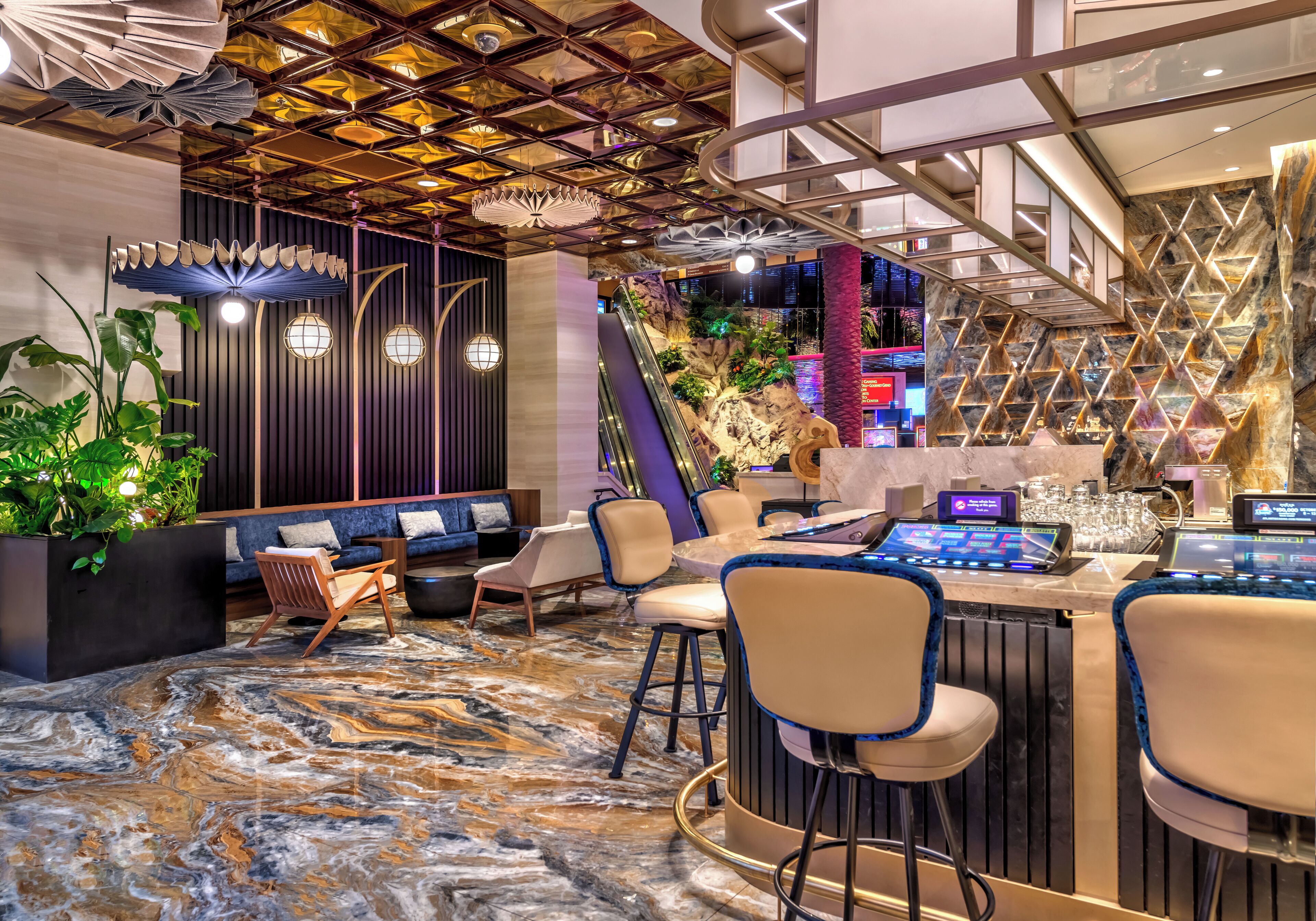 Un área de bar moderna con asientos, piso de mármol y techo decorativo.