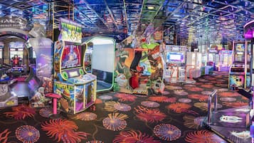 Experience the excitement of classic arcade games, including Teenage Mutant Ninja Turtles and Fireteam Raven, in this vibrant gaming space.