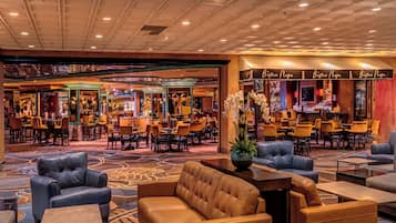 Um hall de hotel com várias áreas de estar, um bar e um restaurante chamado Bistro Napa.