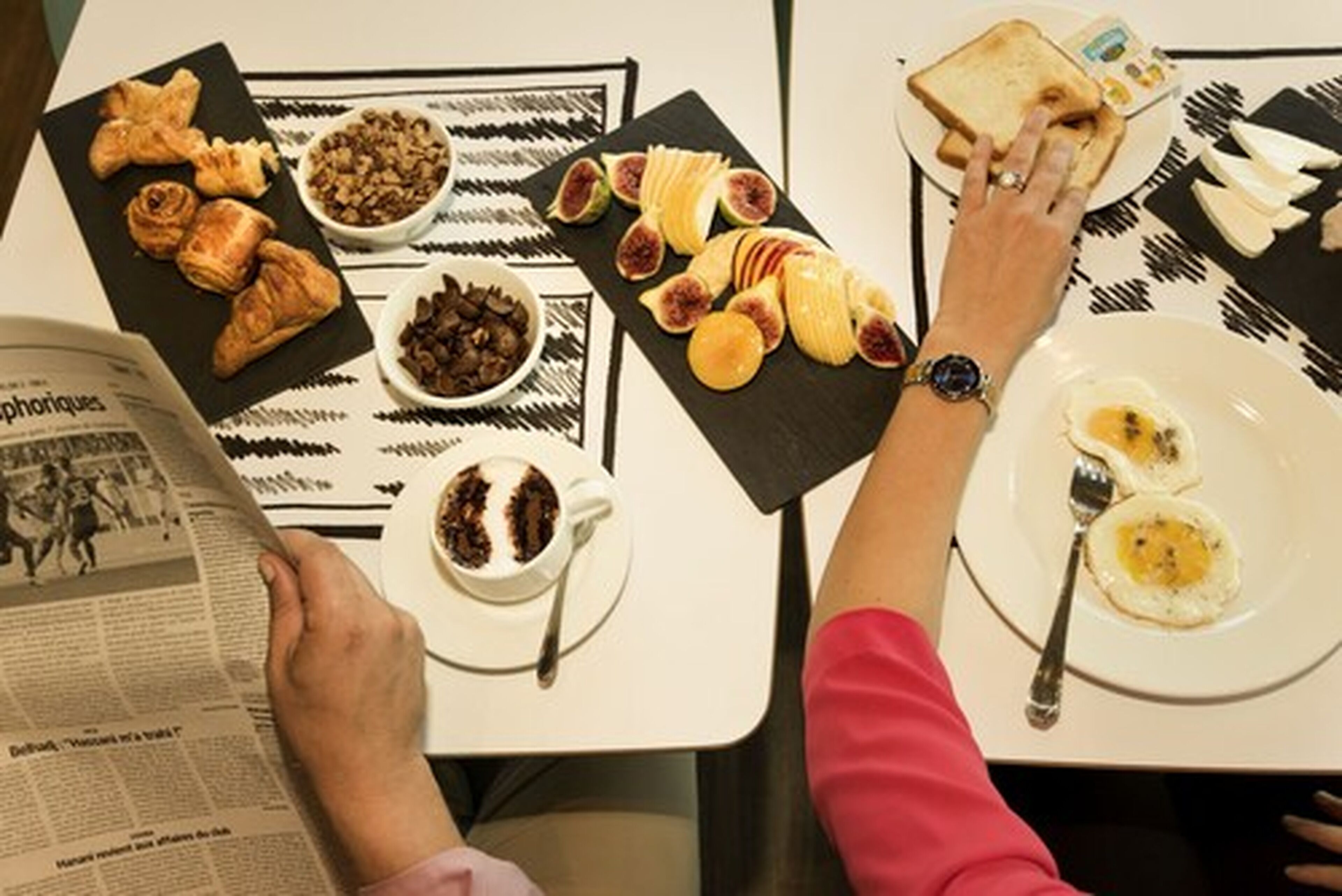 Un desayuno con croissants, frutas y huevos sobre una mesa.