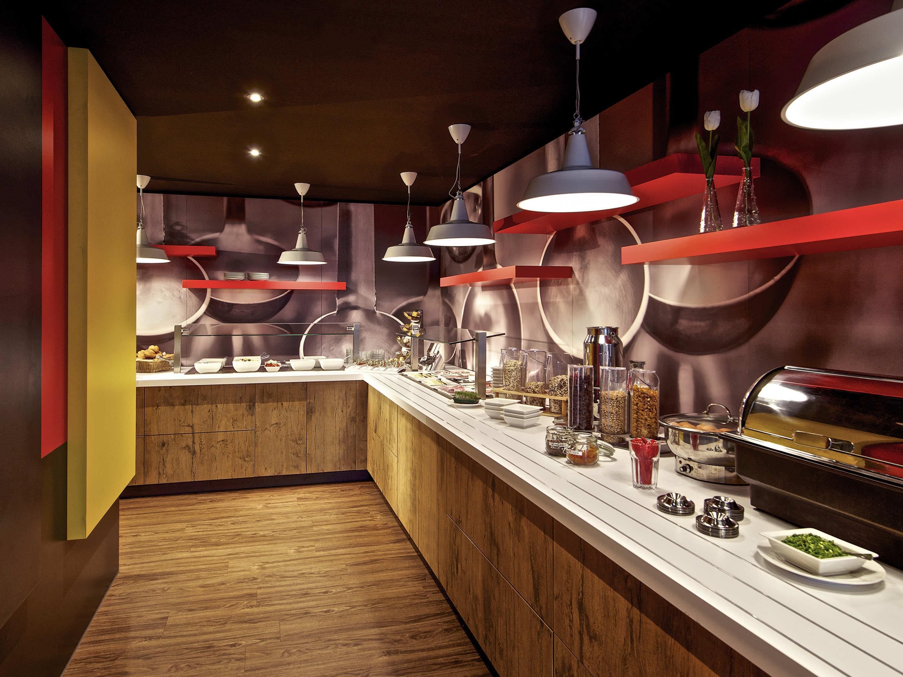 Een moderne buffetopstelling met meerdere bedieningspunten, een houten vloer en moderne verlichtingsarmaturen.