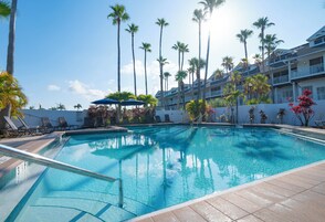 Una piscina al aire libre, sillones reclinables de piscina