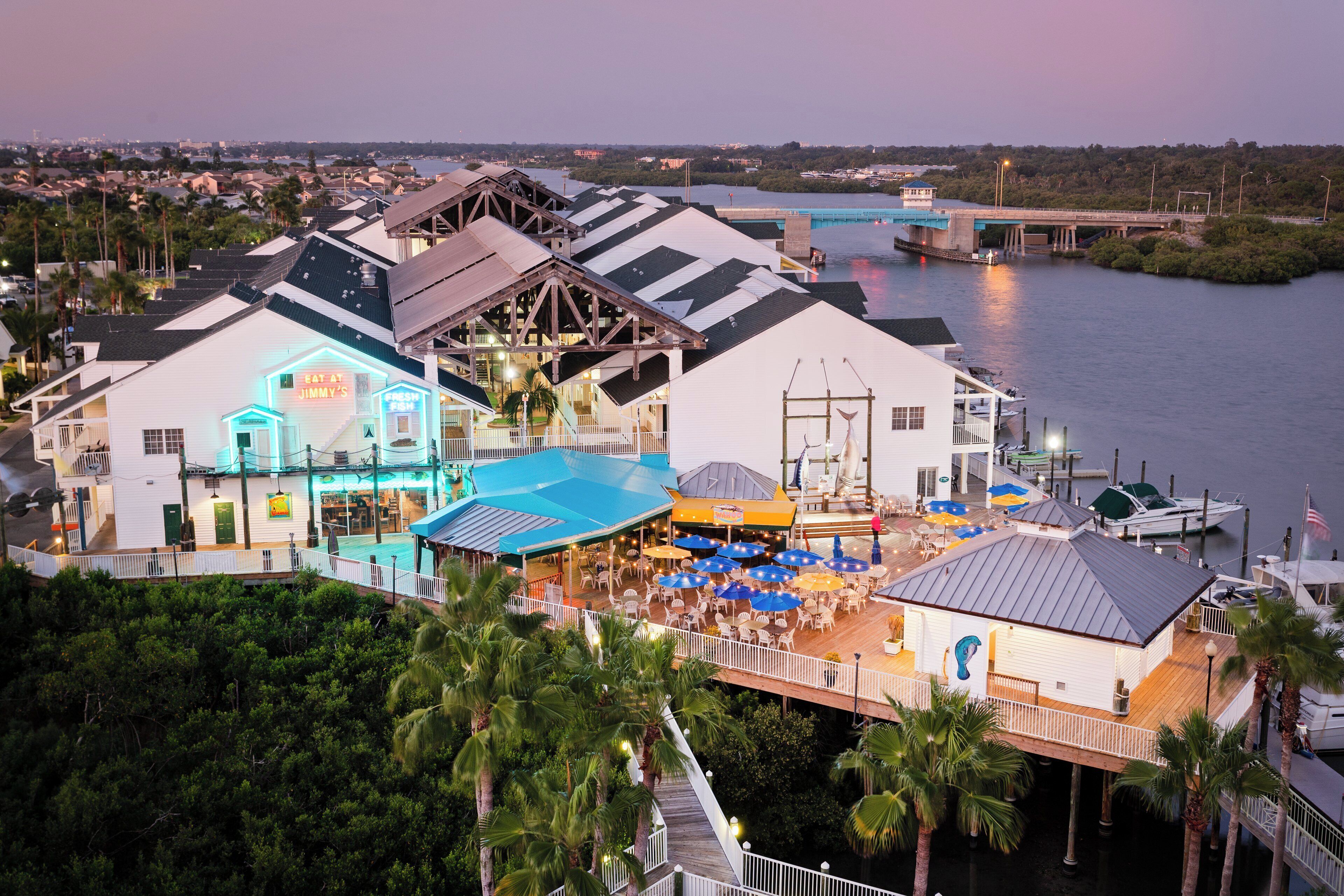 A waterfront property with a dining area, outdoor seating, and a view of the water.