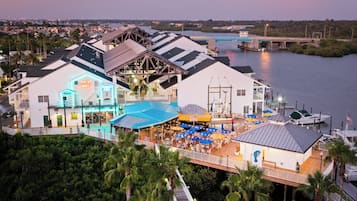 A waterfront property with a dining area, outdoor seating, and a view of the water.