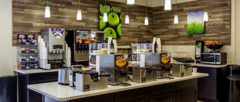 A food service area with waffle makers, a waffle station, and a microwave.